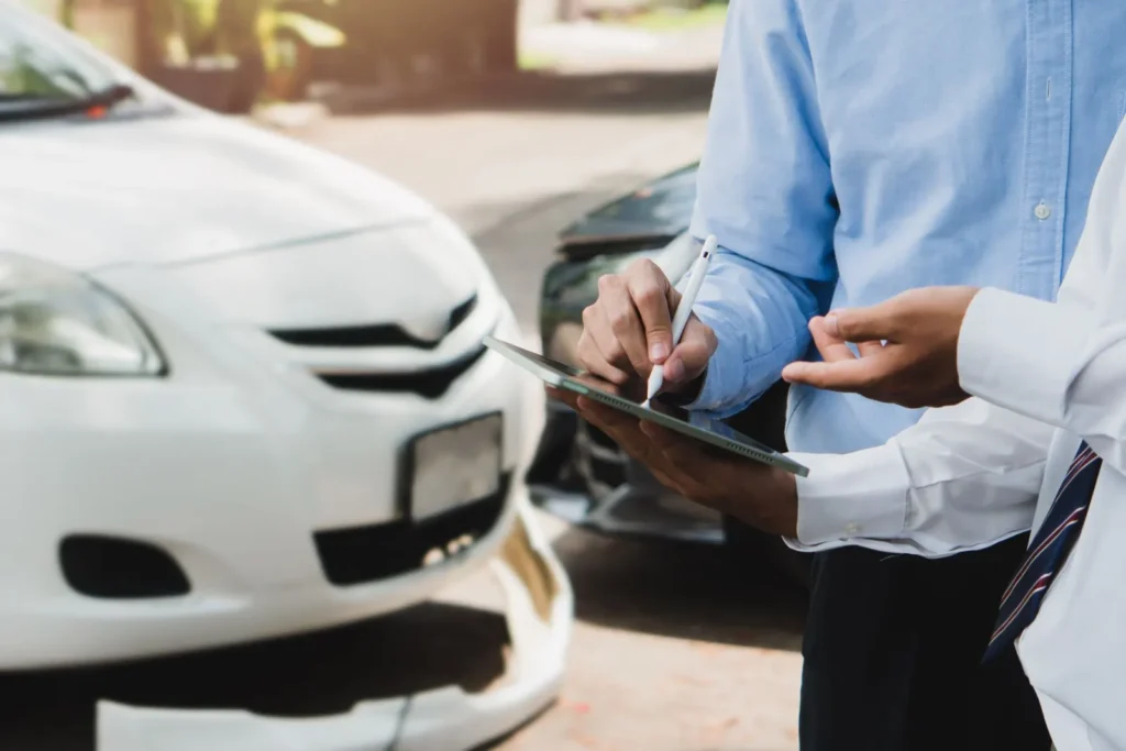 Zwei Geschäftsleute prüfen eine Schadensmeldung für das Auto auf dem Tablet